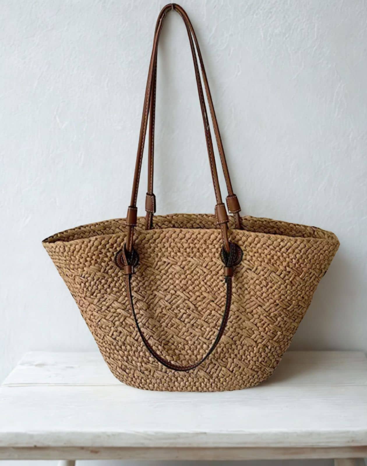 Woven straw tote bag with brown leather straps
